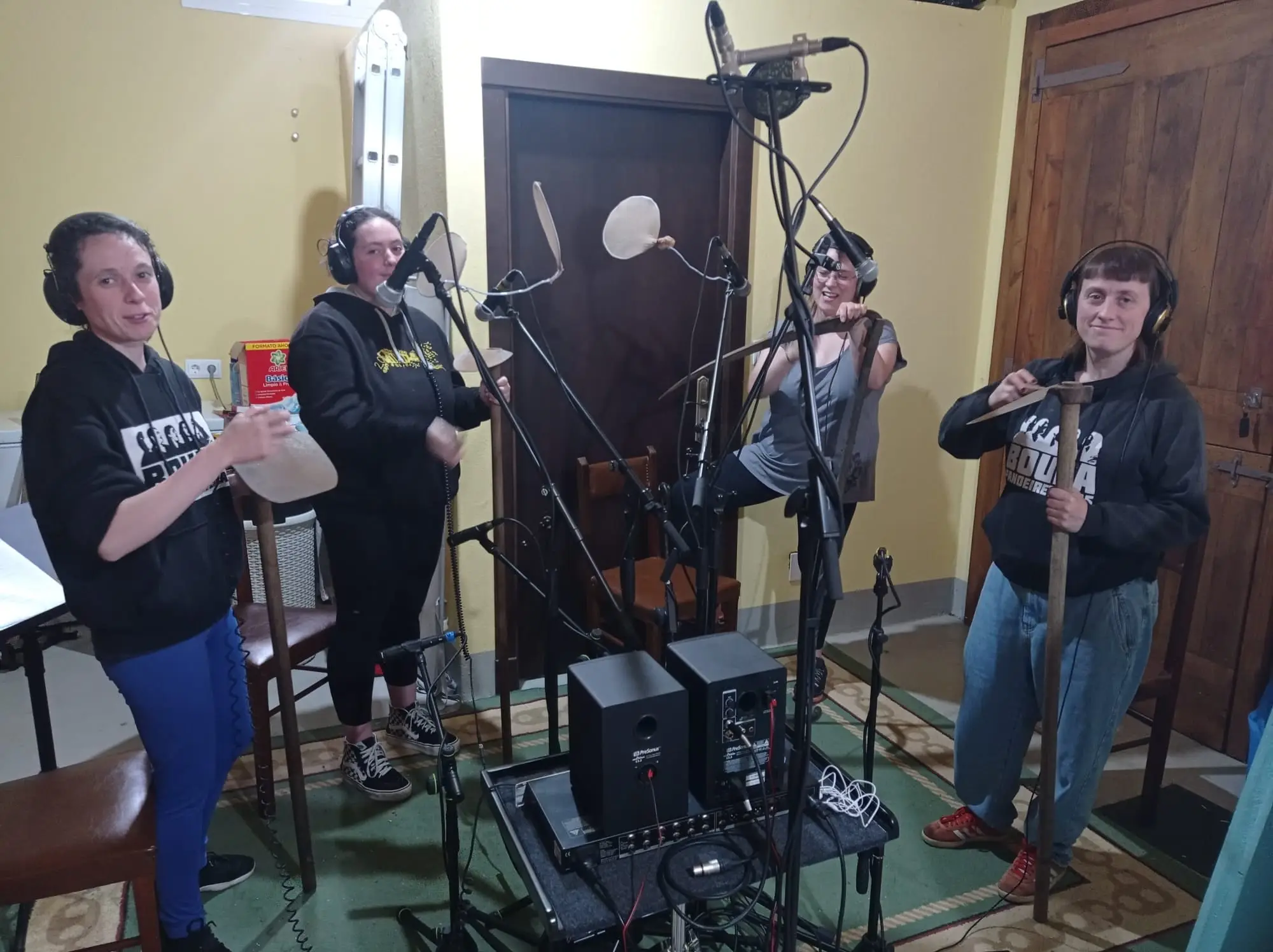 Catro mulleres con auriculares gravan de pé