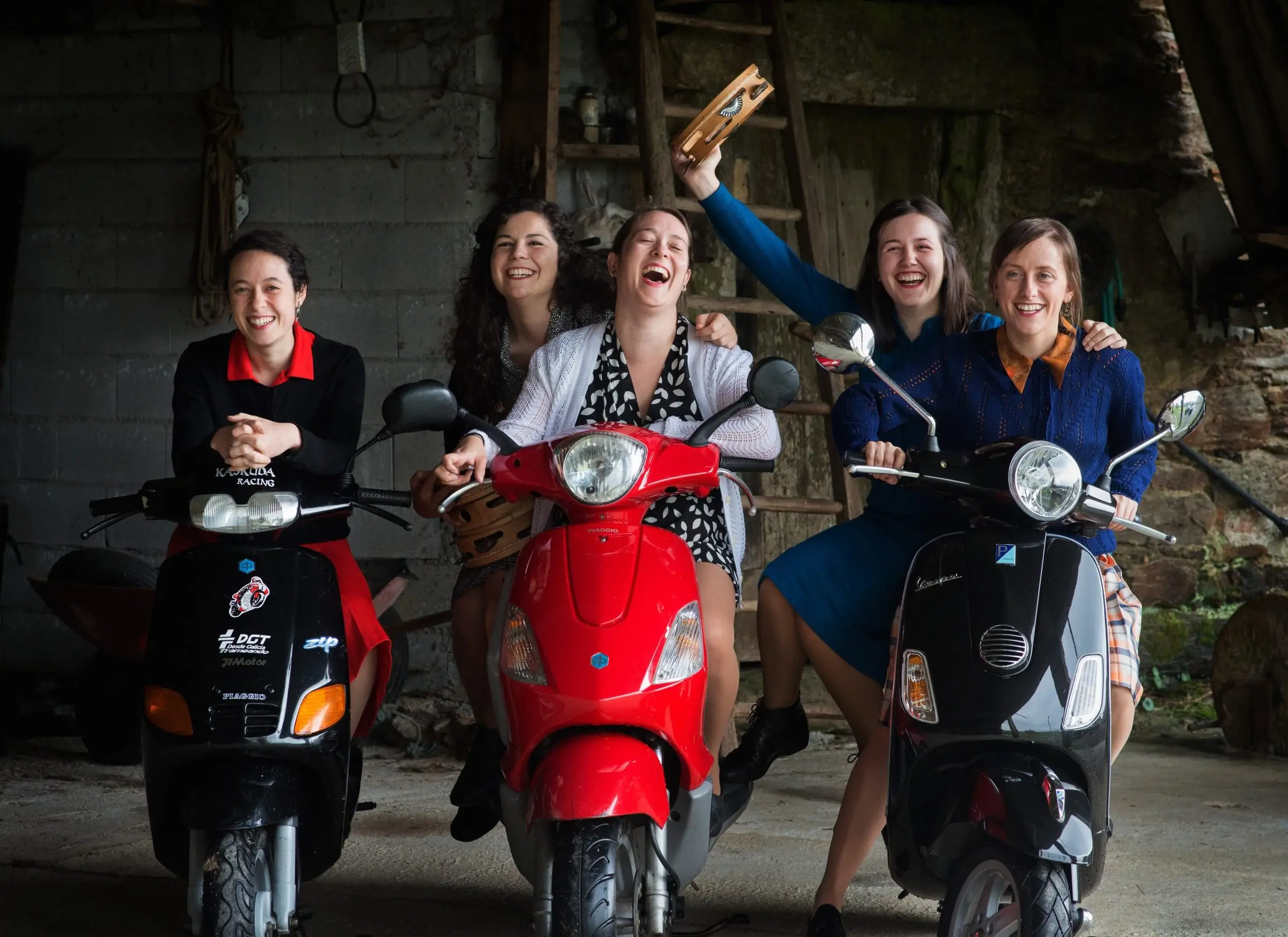 Cinco mulleres rin subidas a tres motos nun alpendre