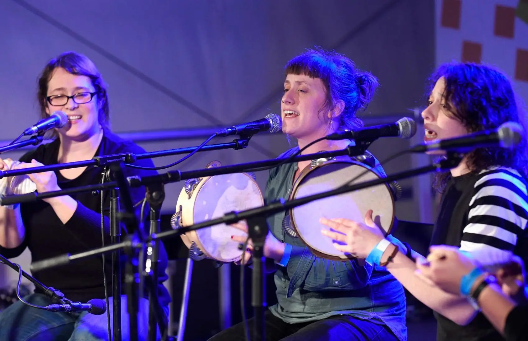Tres Bouba cantan e tocan a pandeireta baixo luces azuis