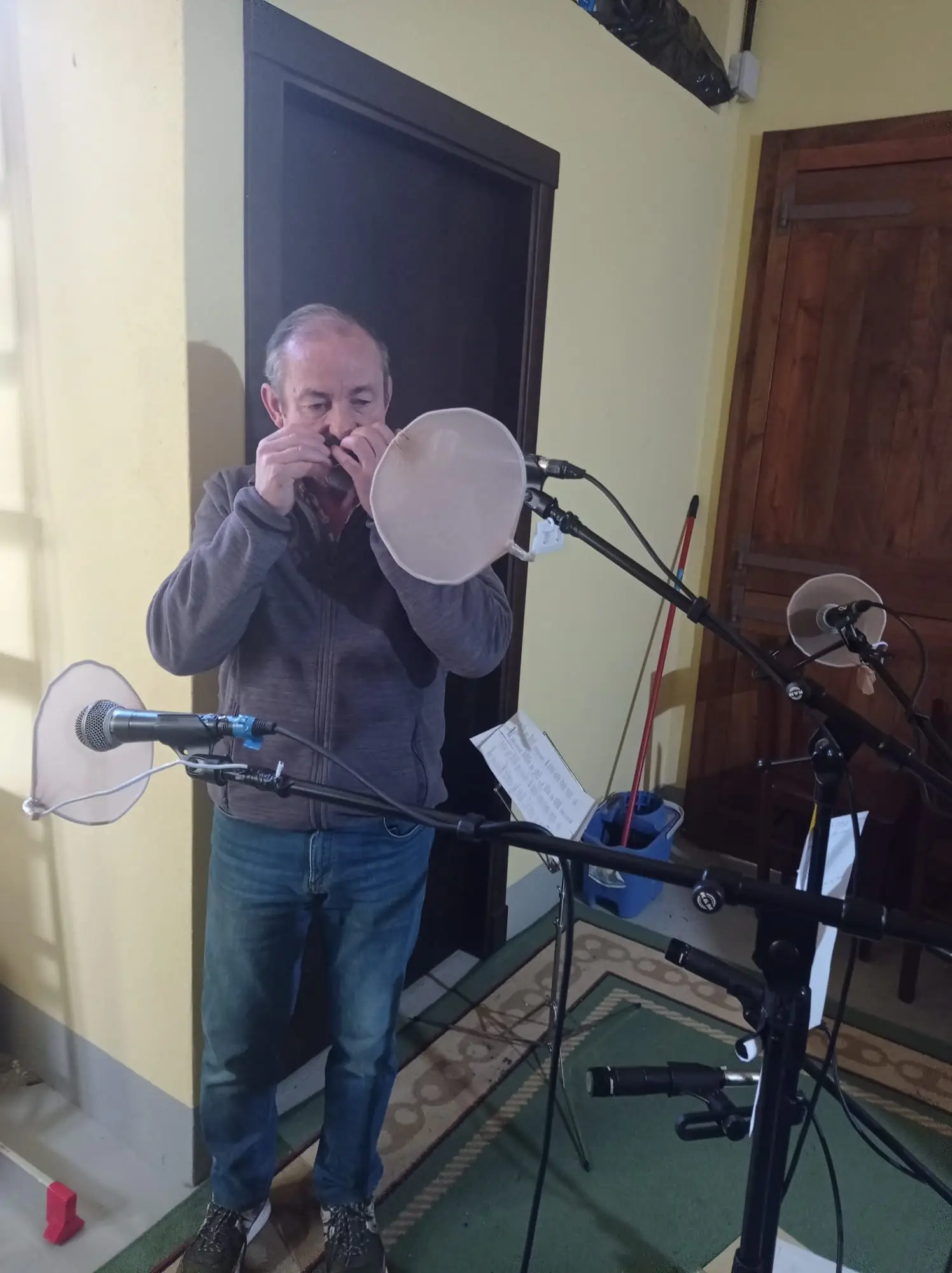 Un home toca diante dun micrófono
